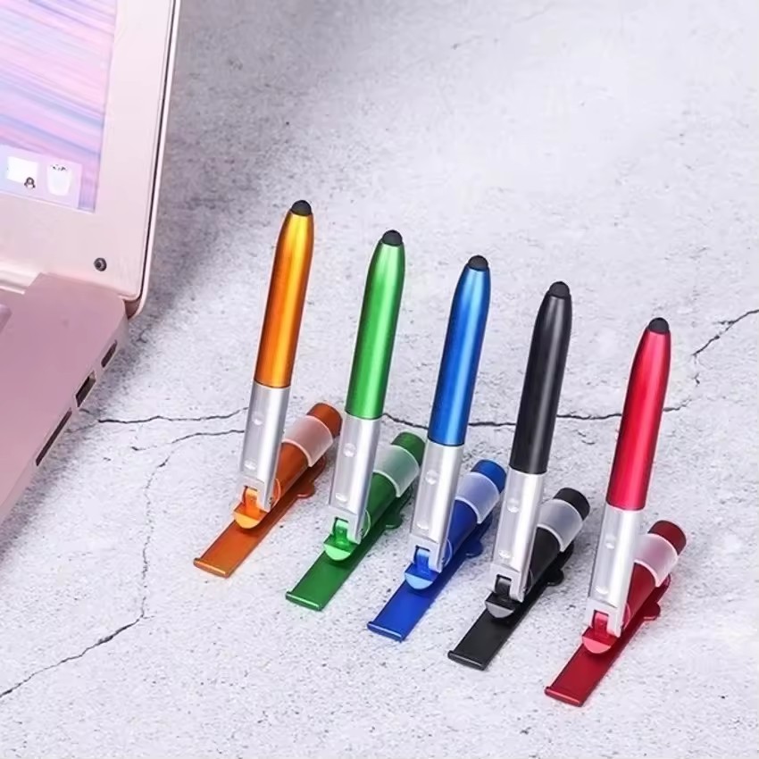 Writing Tools - ปากกาลูกลื่นอเนกประสงค์ 4-in-1 พร้อมไฟ LED ที่วางโทรศัพท์แบบพับได้ สำหรับอ่านหนังสือและเขียนในเวลากลางคืน